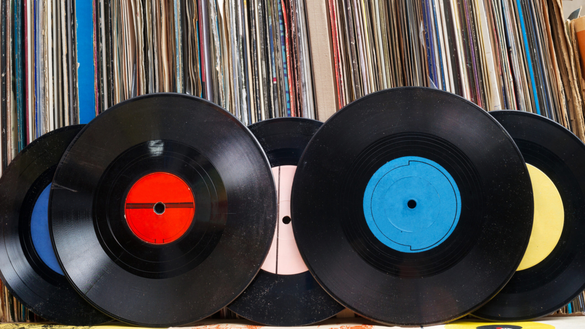 Vinyl record with copy space in front of a collection of albums dummy titles, vintage process