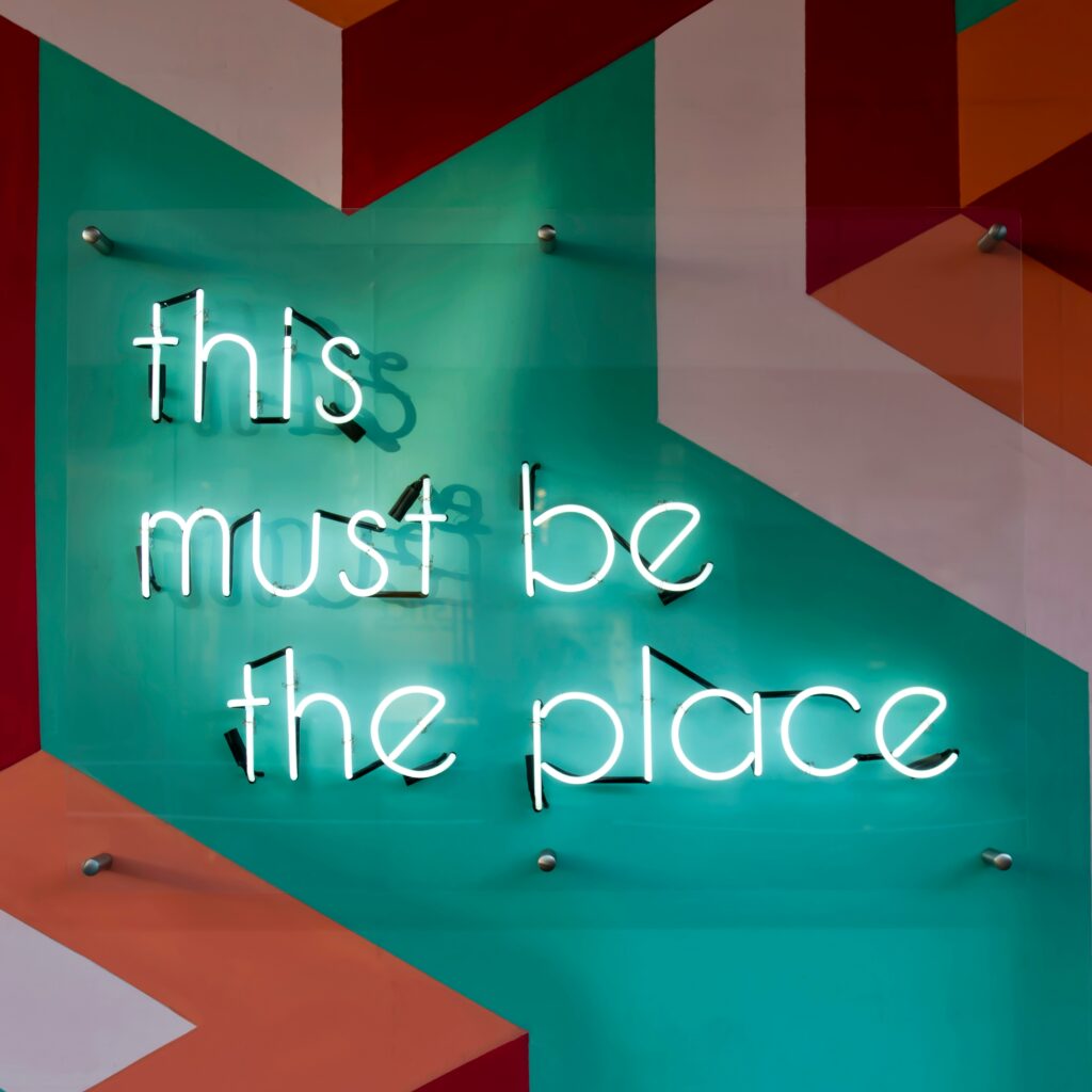 The sentence "this must be the place" in the form of a neon sign is used for Alan Philip Muller's My Blog Page