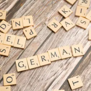 Wooden letter tiles spelling the word 'German' on a table, representing the journey where I am improving my German through learning and daily practice.